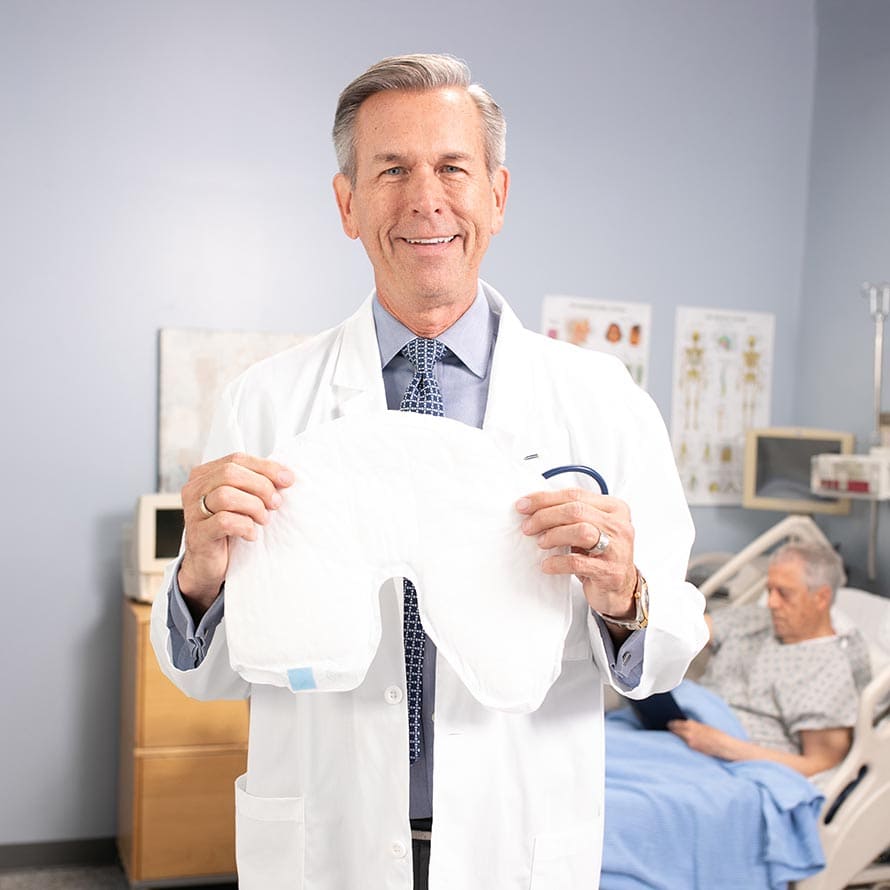 Doctor holding a QuickChange Wrap in a hospital room with a patient in the background